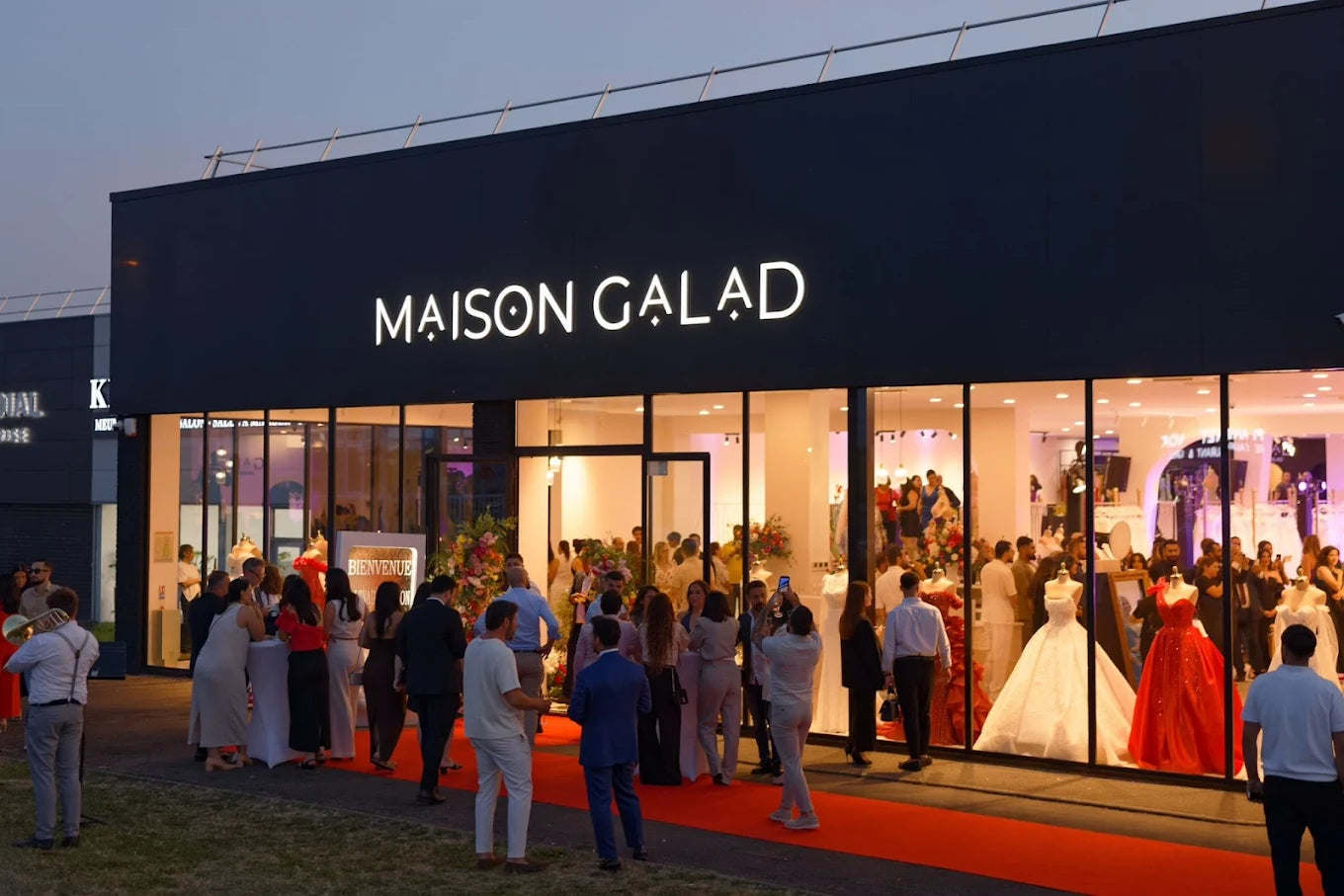 Façade du showroom Maison Galad lors d’un événement d’inauguration, avec vitrines présentant des robes de mariée et de soirée, à Groslay.