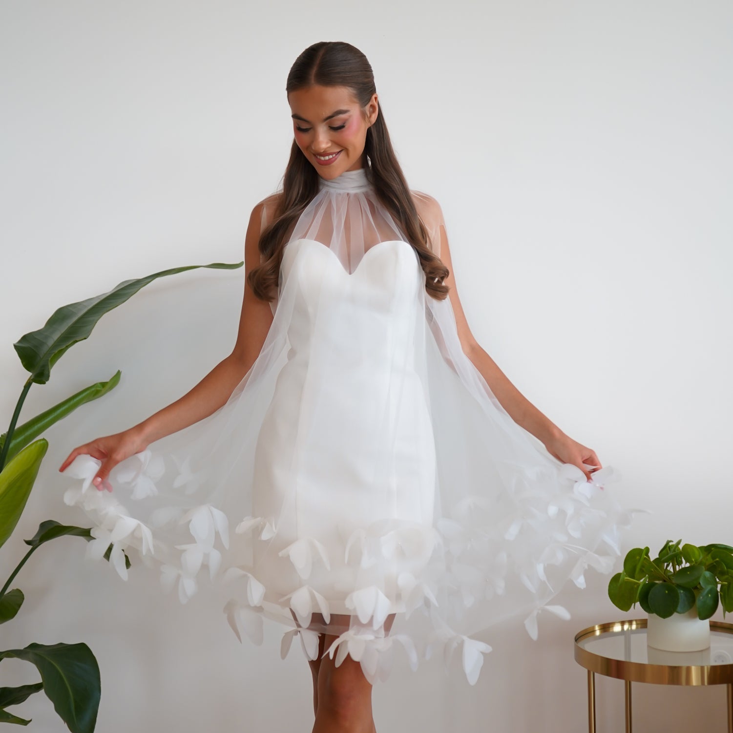 Robe de mariée courte ILYA Maison Galad, en lamé de soie blanc avec cape en tulle ornée de pétales, au style moderne, léger et poétique, idéale pour un mariage civil.