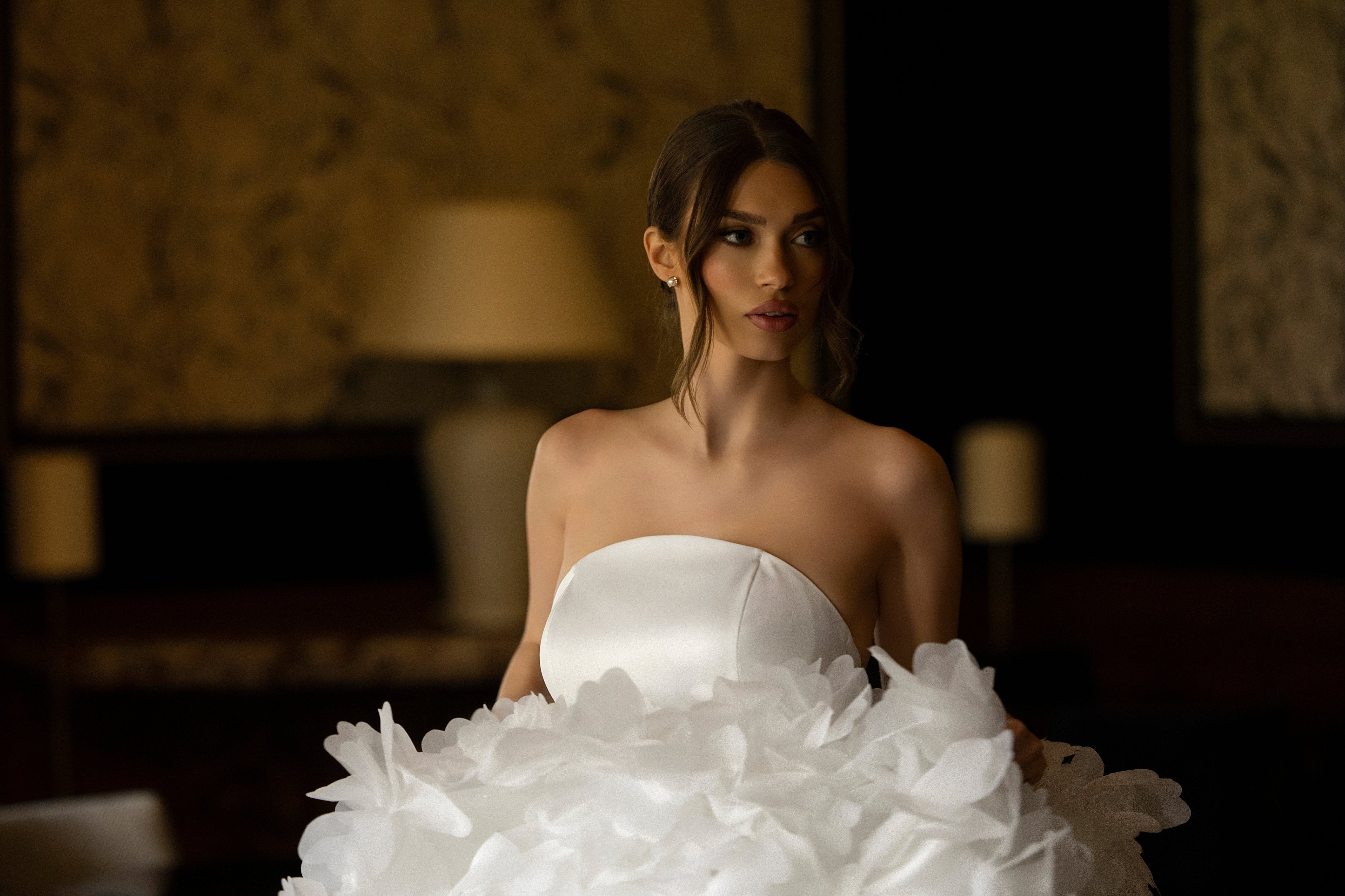 Robe de mariée sur mesure avec bustier en satin et jupe volumineuse ornée de fleurs blanches, disponible exclusivement en magasin Maison Galad.